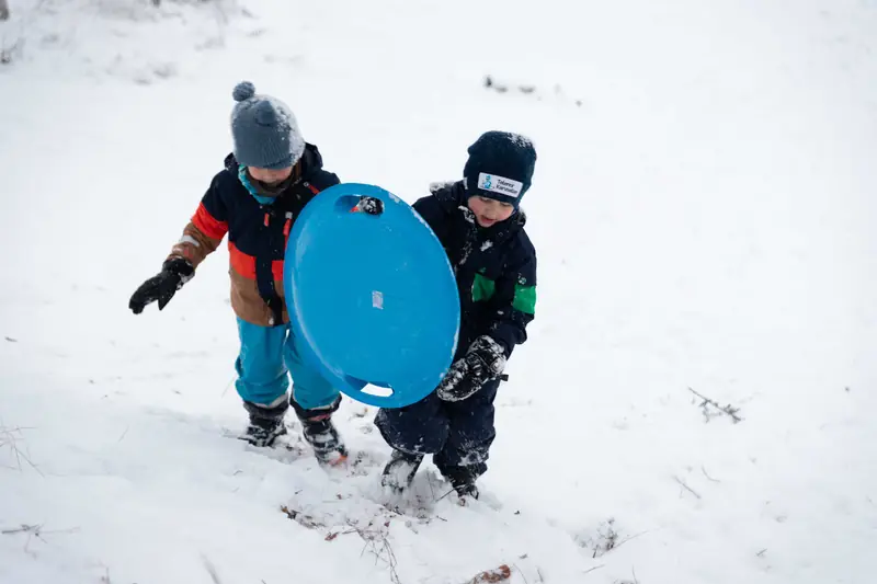 To gutter med akebrett i snøen