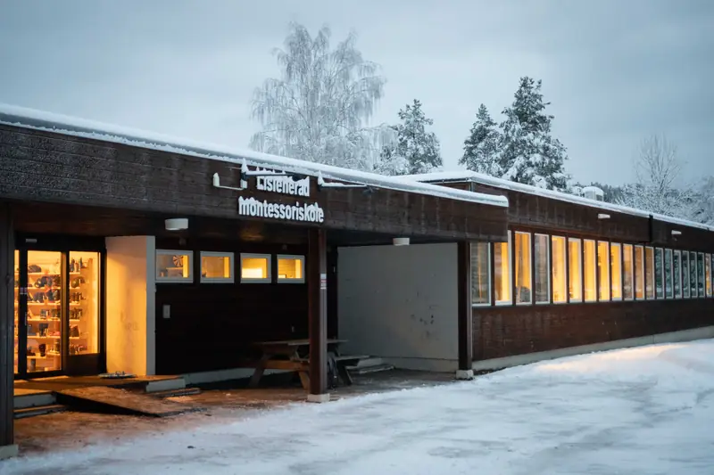 Skolebygget i Lisleherad med lys i vinduene en snødekt vintermorgen